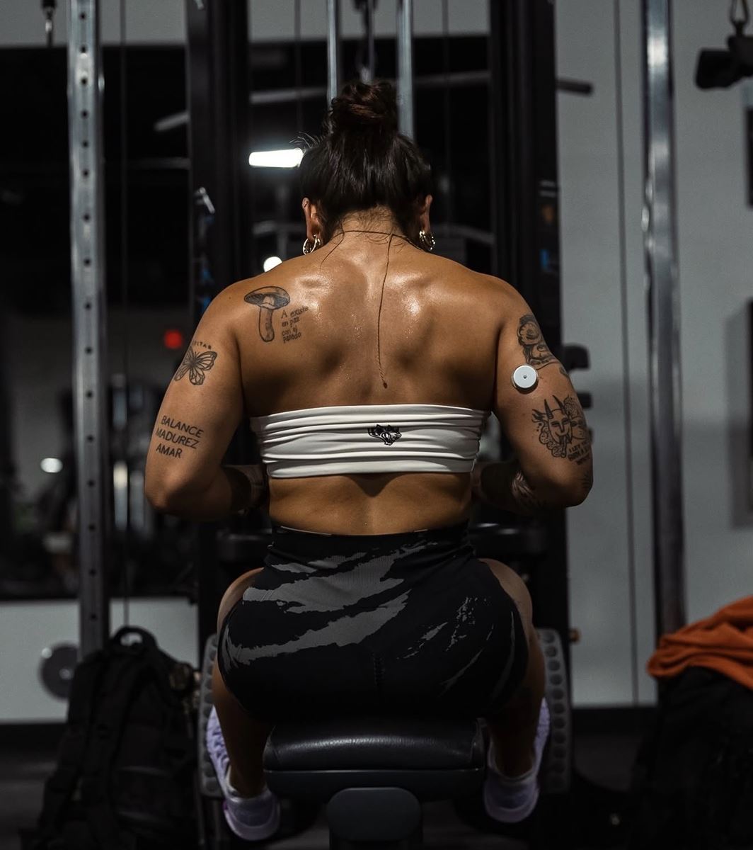 Mariana Gov training at the gym, photographed from behind during a seated cable row